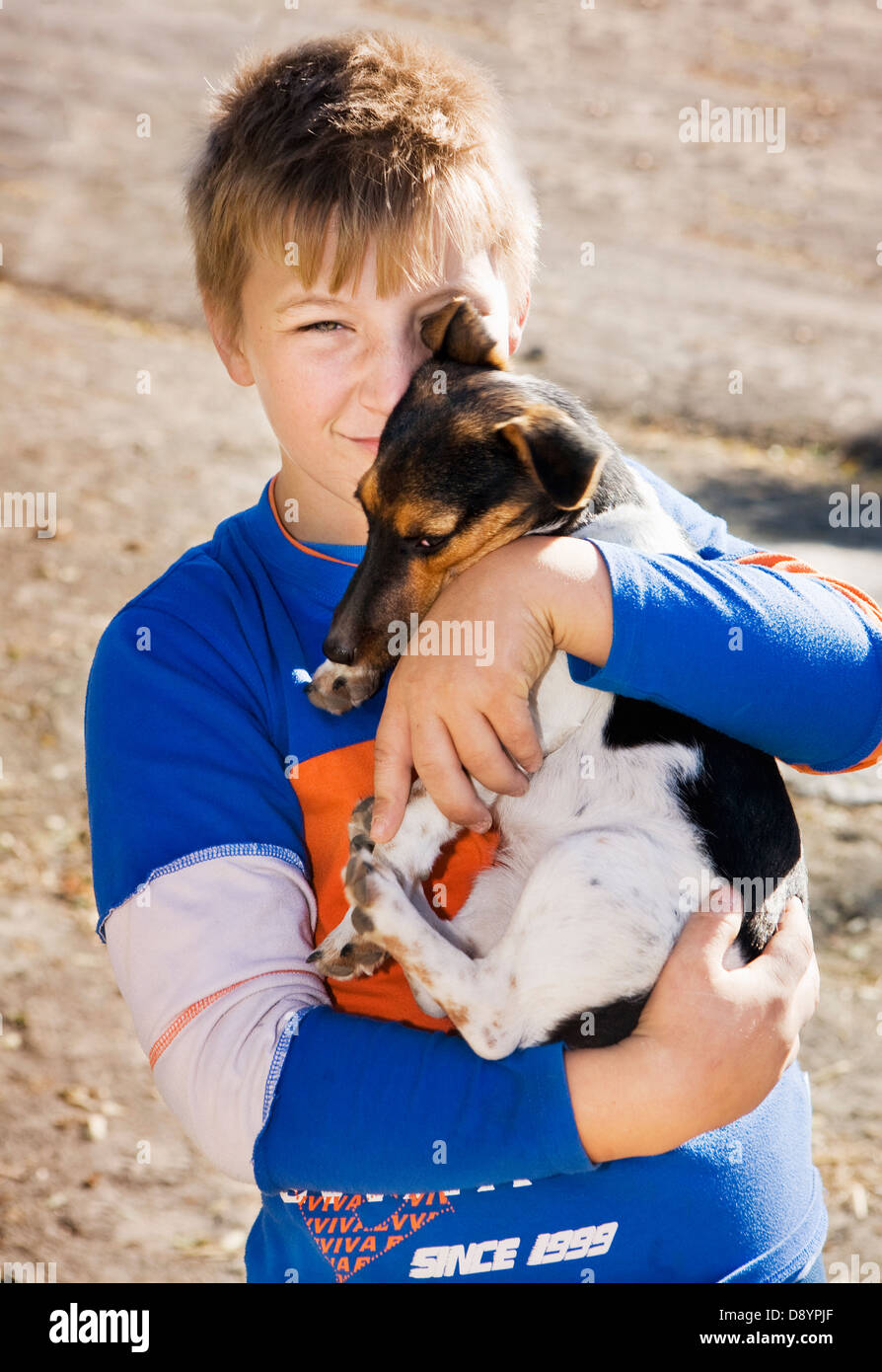 Teenage boy holding dog Stock Photo