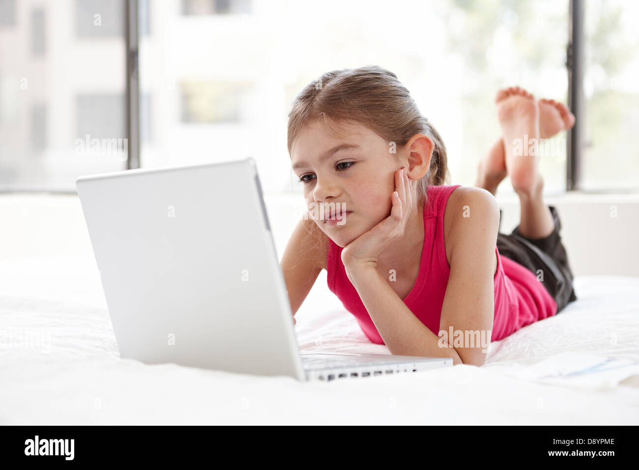 Girl with laptop on bed Stock Photo Alamy