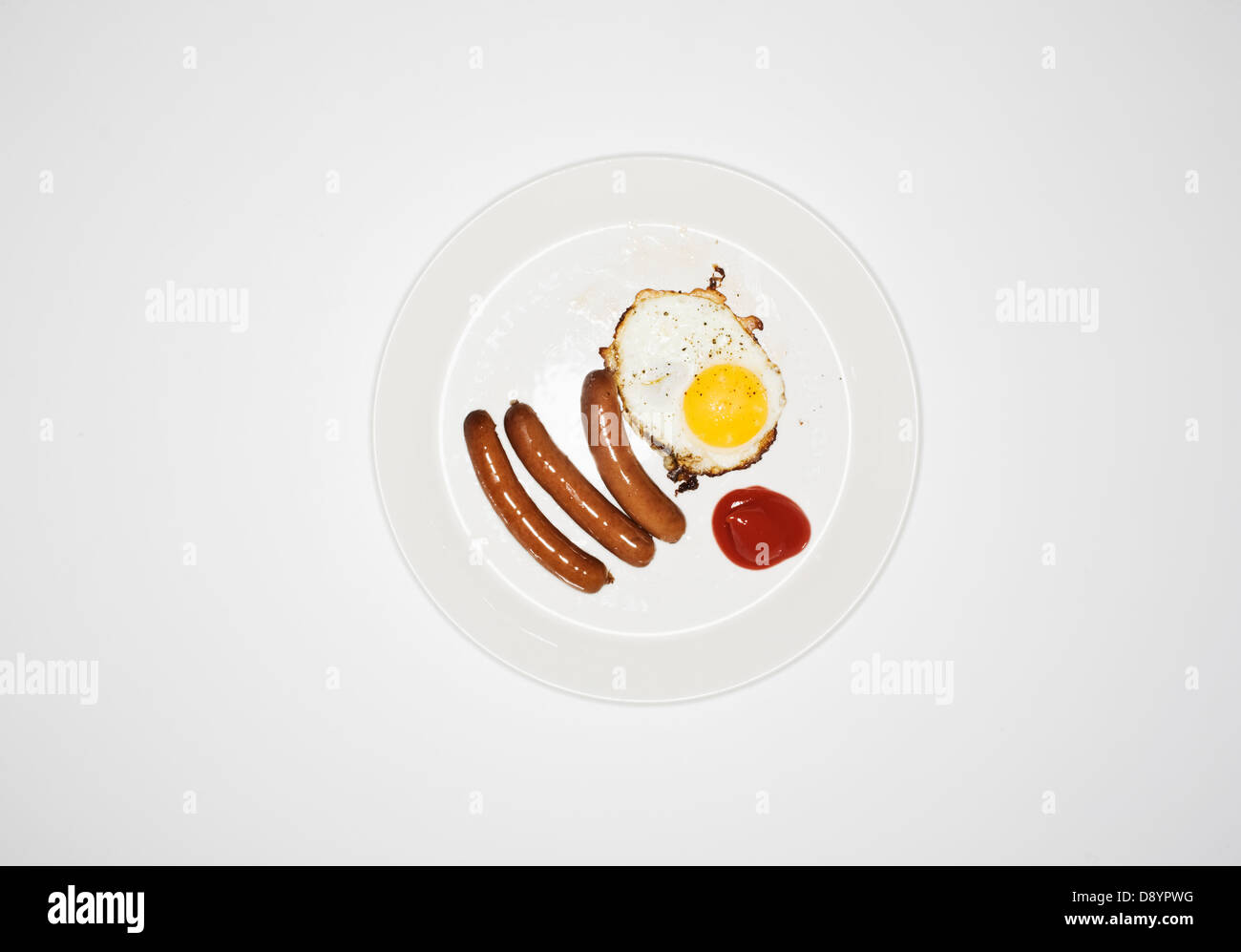 Plate of sausage and fried egg on white background Stock Photo
