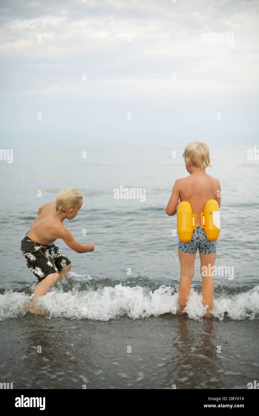 Two boys playing by the sea Stock Photo - Alamy