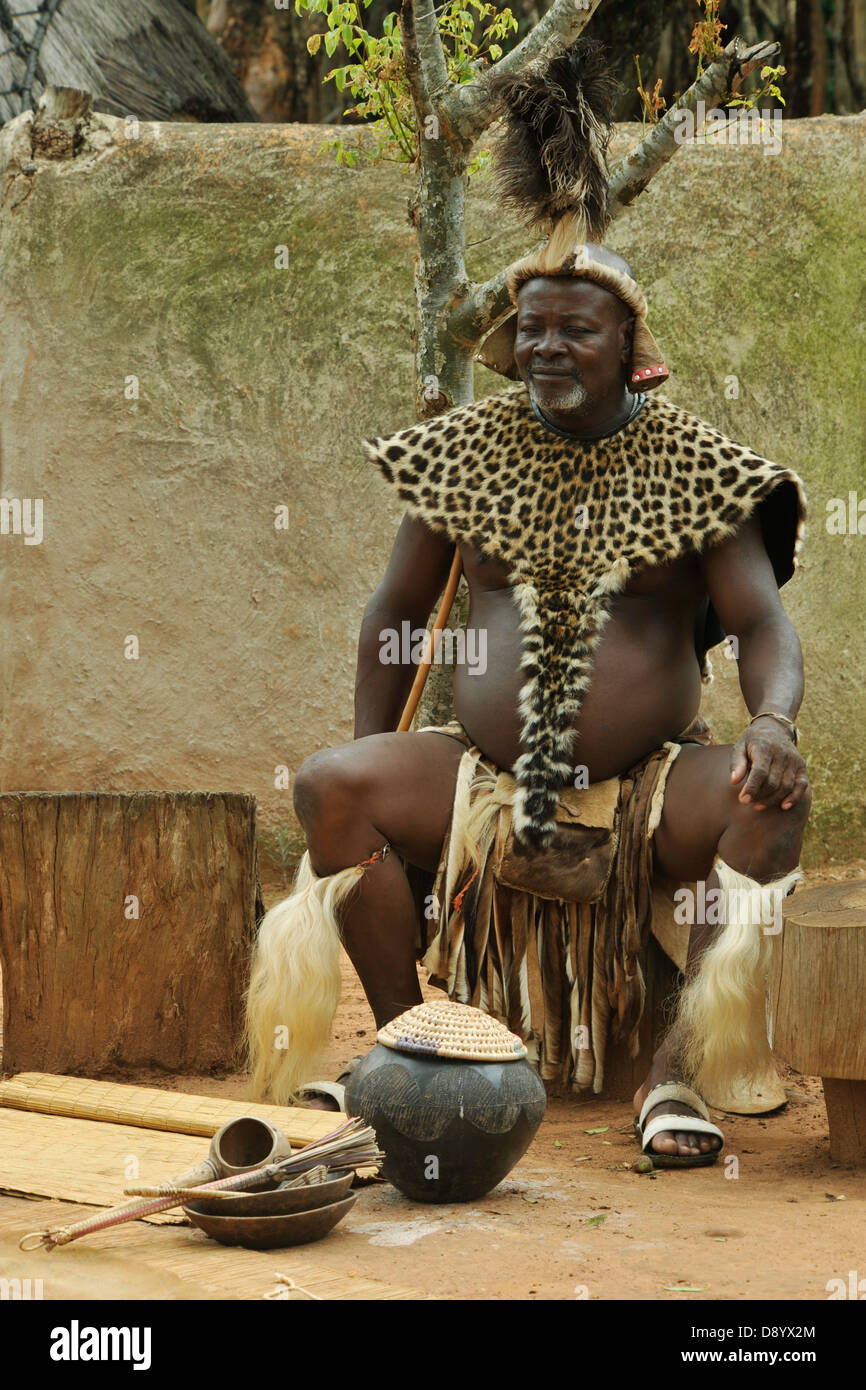 People, senior adult man, Zulu chief, ceremonial dress, sitting, pot of traditional African beer, ethnic, Shakaland, KwaZulu-Natal, South Africa Stock Photo