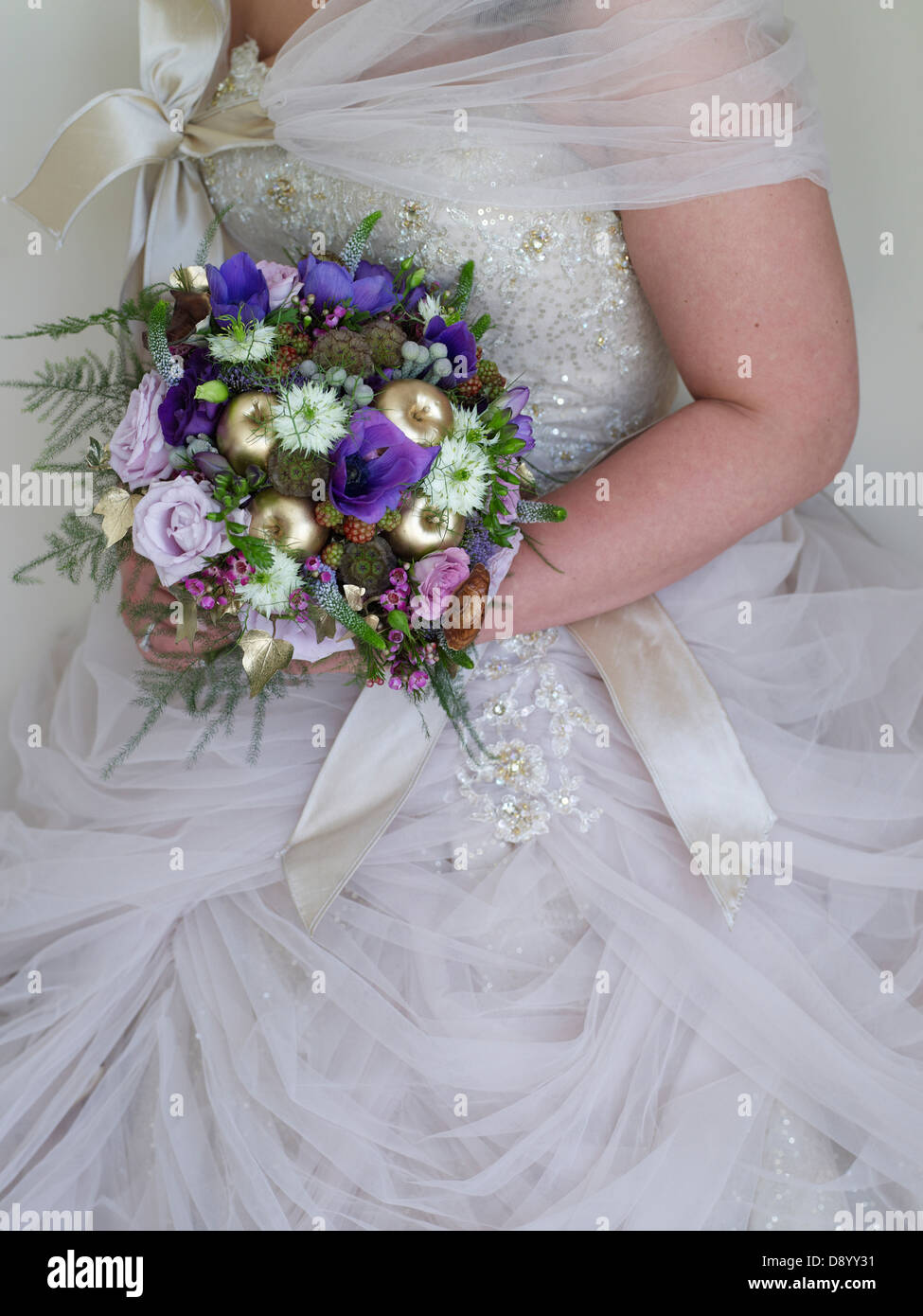 A Bride In A Big White Wedding Dress And Shrug Holding A Bouquet