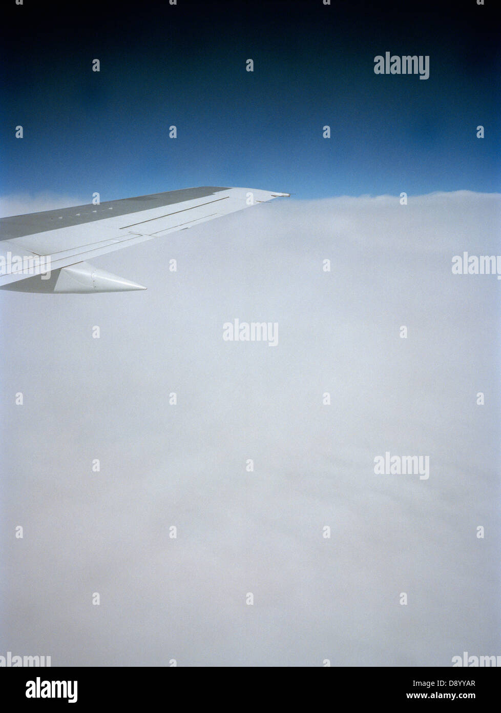 Airplane wing above clouds. Stock Photo