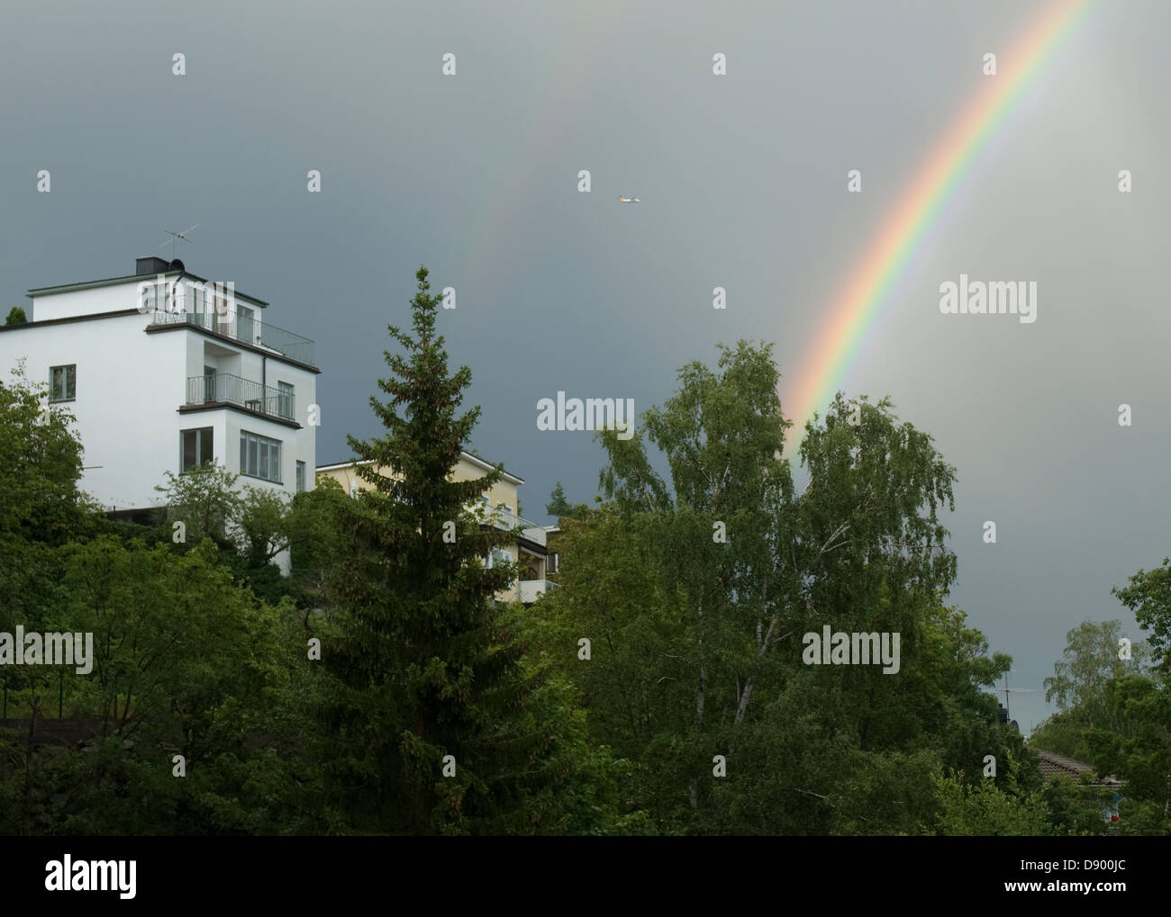 A rainbow over a white house. Stock Photo