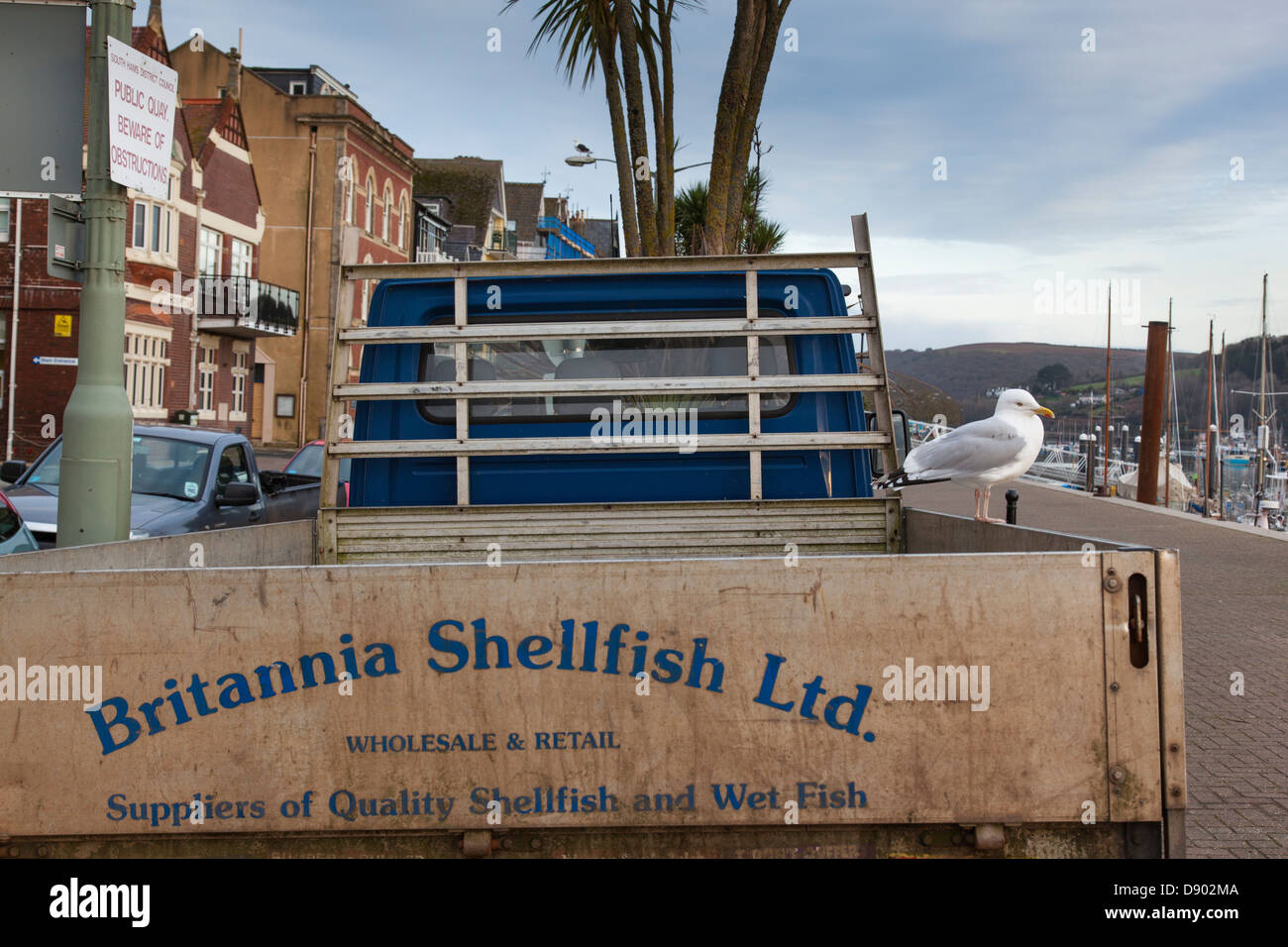 Pickup truck awaiting a catch of shellfish on the quayside whilst a ...