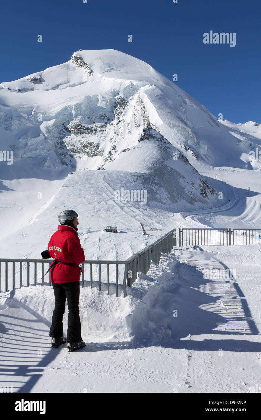 SAAS-FEE, VALAIS, SWITZERLAND. The peak of the Allalin mountain. In the foreground a tourist on the viewing platform. Stock Photo