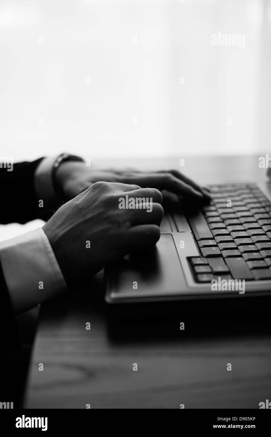 Hands typing on laptop Stock Photo
