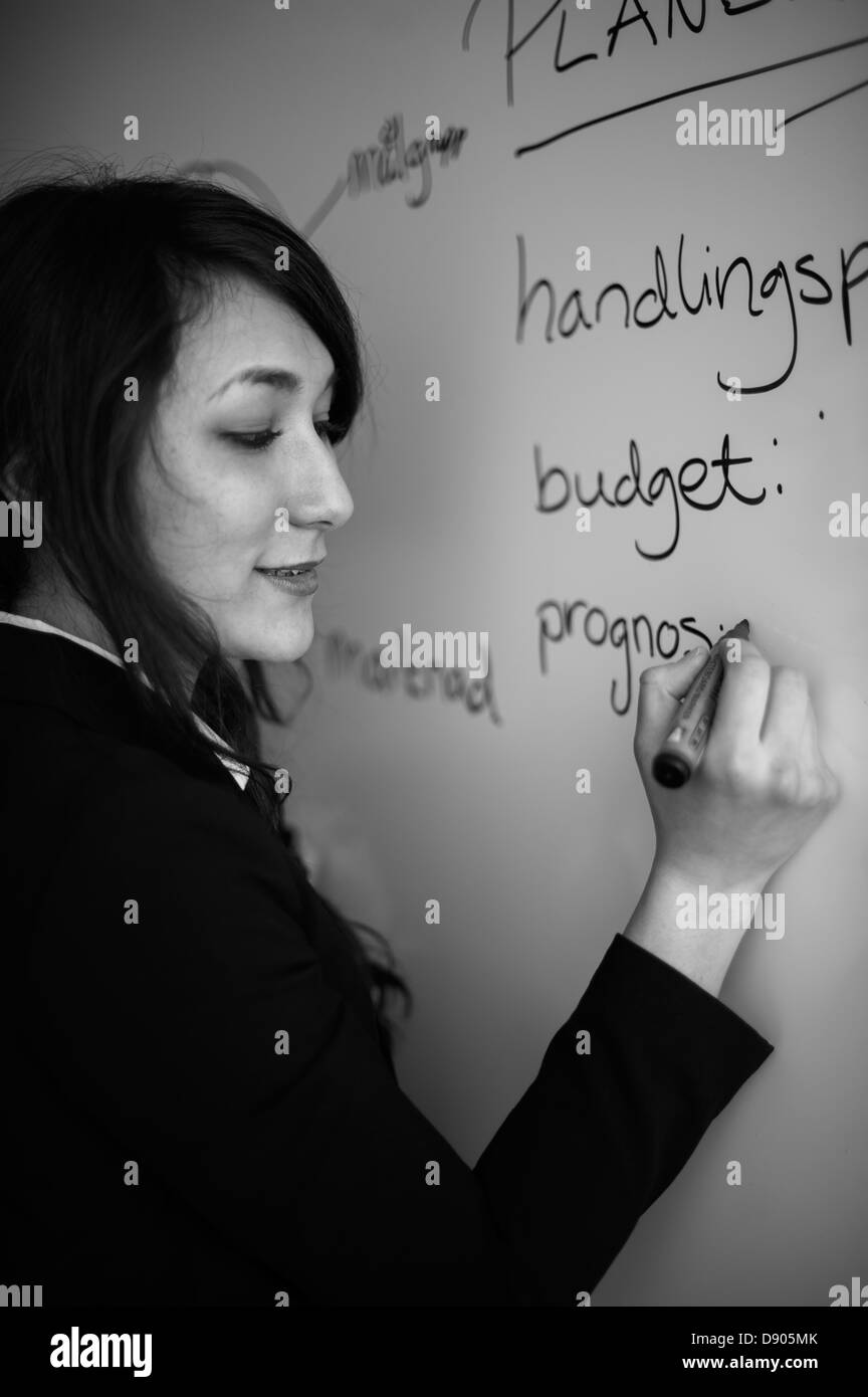 Woman writing on white board Stock Photo