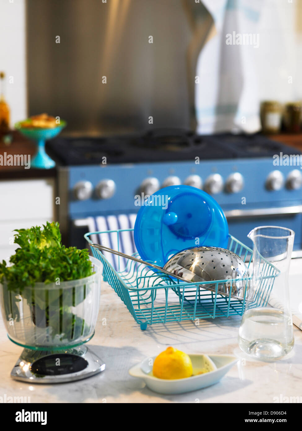 A colander and a salad spinner in a dish rack. Stock Photo