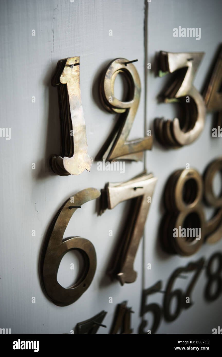 Metal numbers hanging on wall, close-up Stock Photo