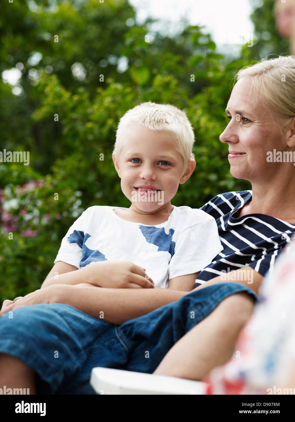 Mother and boy sitting in outdoor chair Stock Photo