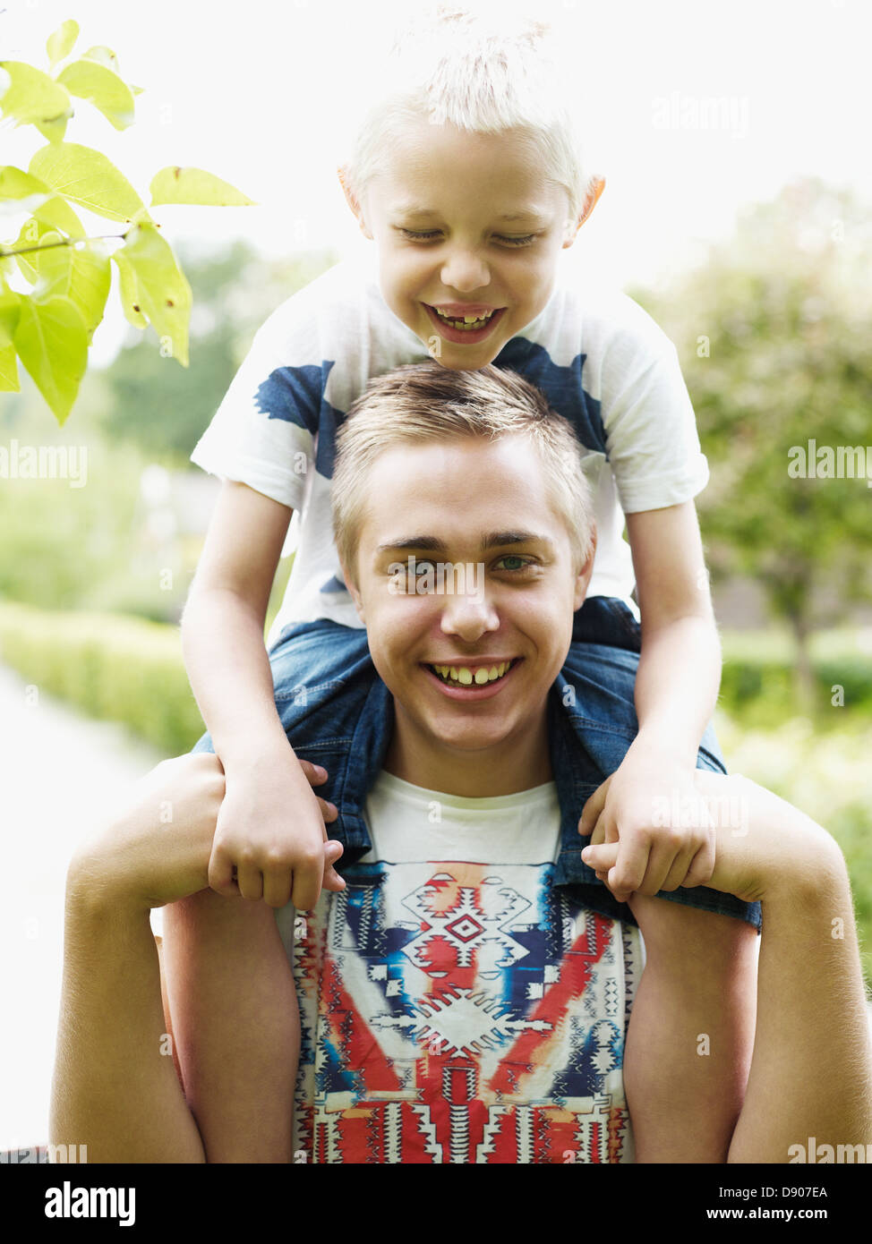 Teenage boy carrying younger brother on shoulders Stock Photo Alamy