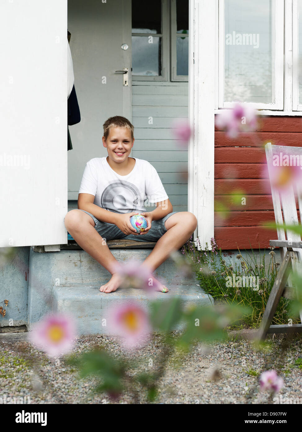 Teenage boy sitting on porch Stock Photo - Alamy
