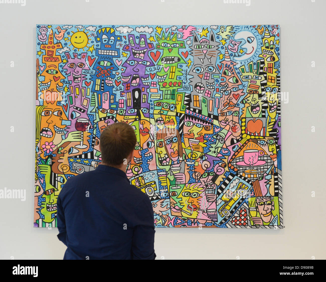 A visitor looks at a painting by artist James Rizzi in Esslingen am Neckar,  Germany, 07 June 2013. One and a half years after the death of popart  artist Rizzi, a retrospective