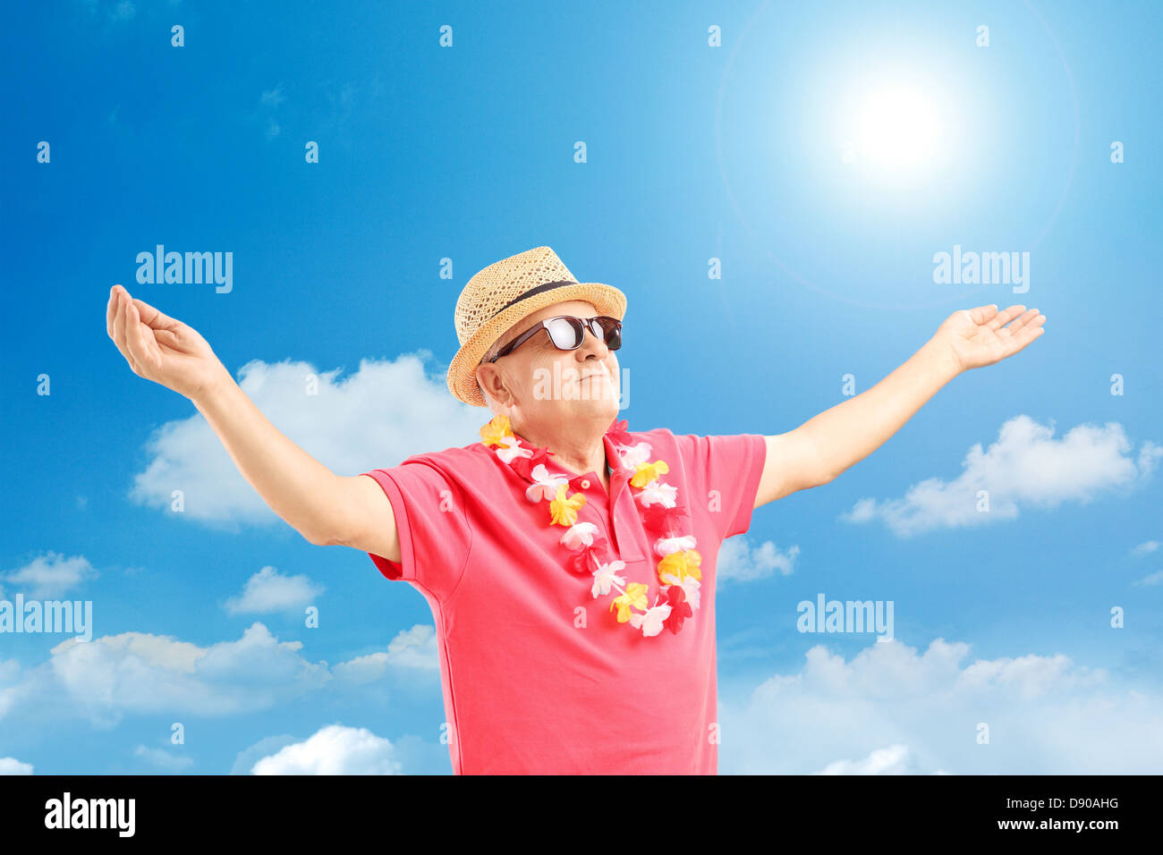 Happy mature man on a vacation spreading his arms on a sunny day Stock Photo