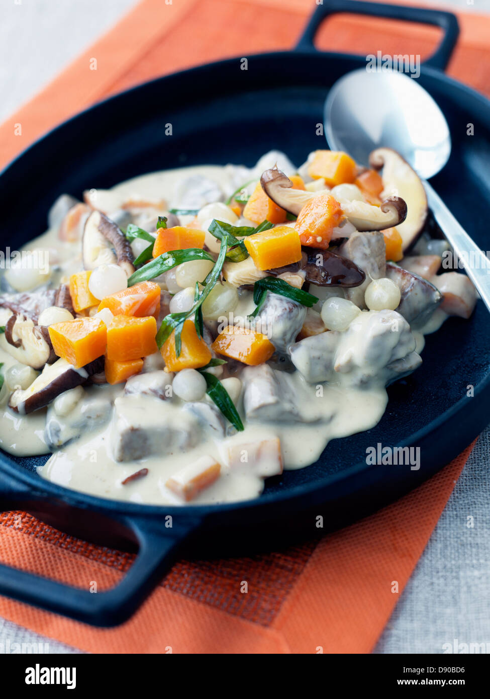 Prepared food in pan with spoon Stock Photo