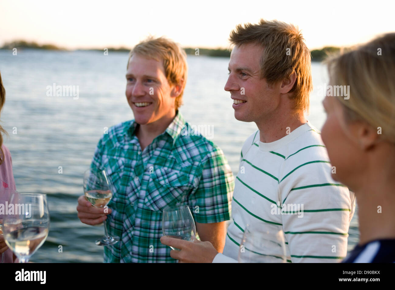 Three persons laughing and drinking, Fejan, Stockholm archipelago, Sweden. Stock Photo