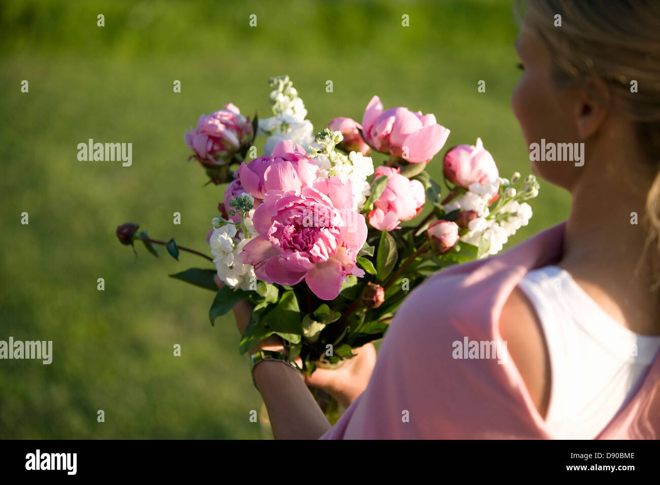 Woman carrying a bunch of flowers, Fejan, Stockholm archipelago, Sweden. Stock Photo