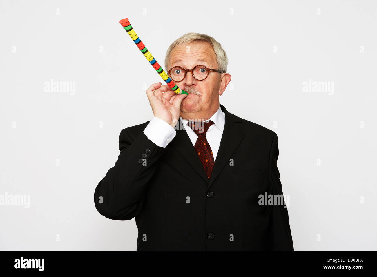 an-older-man-in-a-suit-blowing-in-a-part