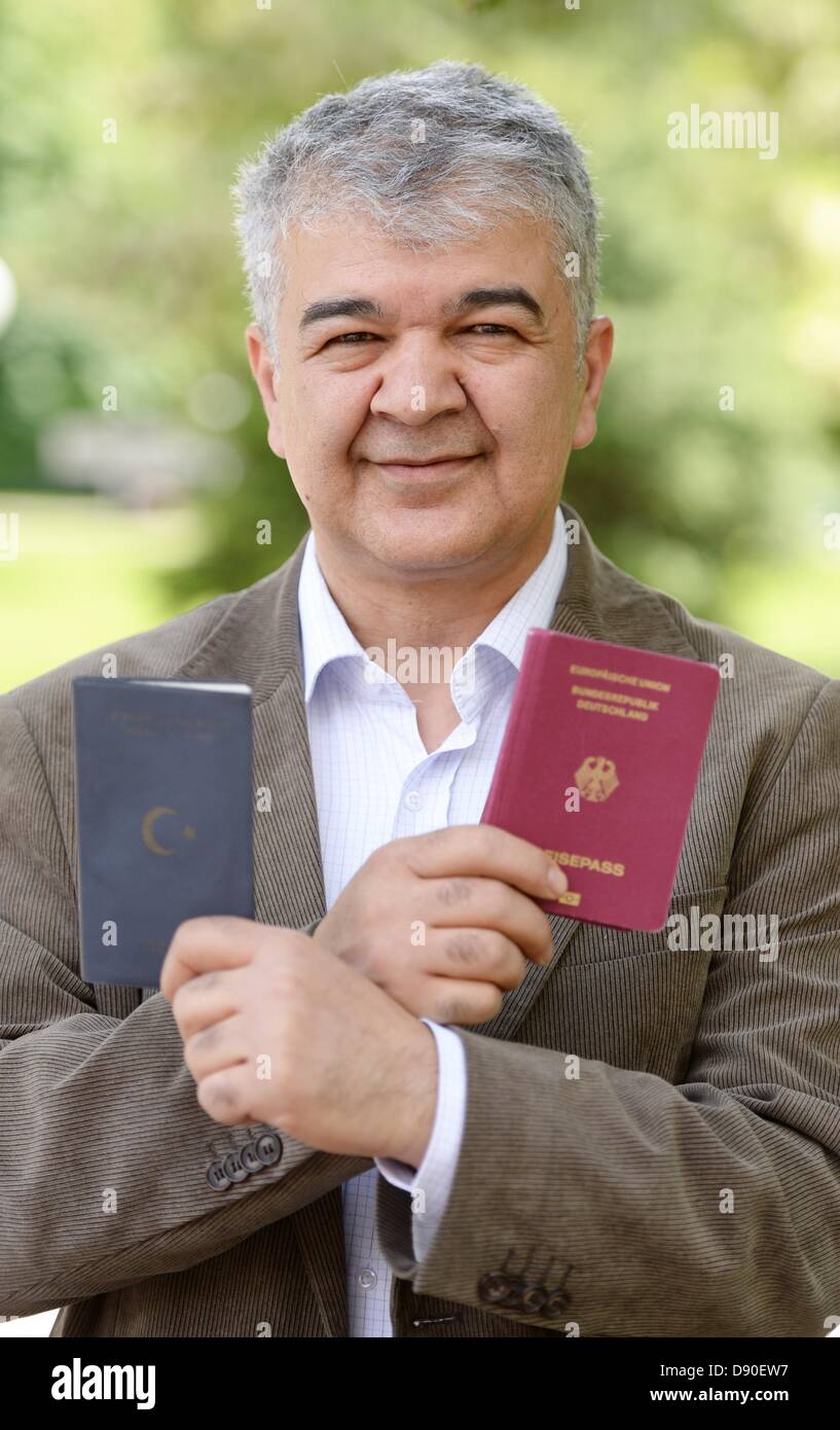Gokay Sofuoglu, Chairman of the Turkish Community in Baden-Wuerttemberg, holds up German (R) and a Turkish passports in Stuttgart, Germany, 07 June 2013. He has double citizenship. Photo: BERND WEISSBROD Stock Photo