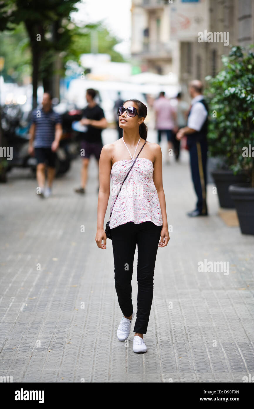 Woman walking in street Stock Photo - Alamy
