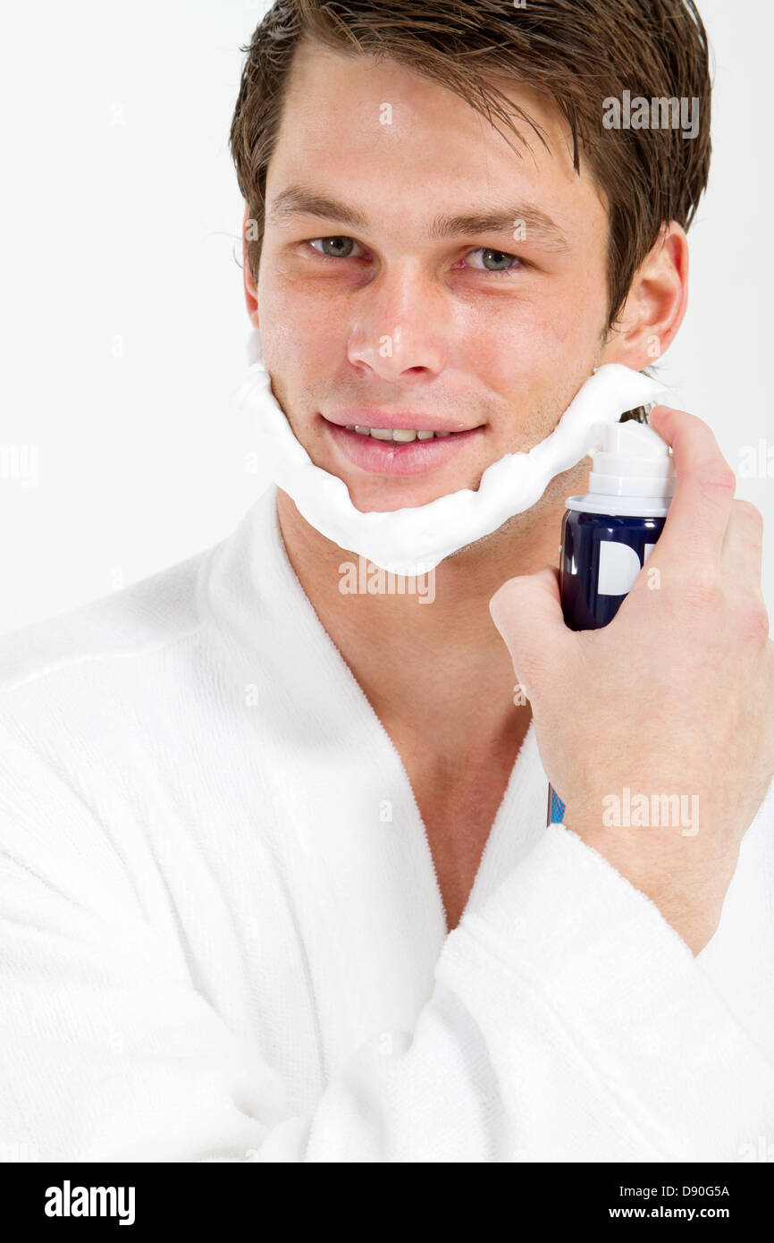 handsome young man apply shaving foam on face in bathroom Stock Photo