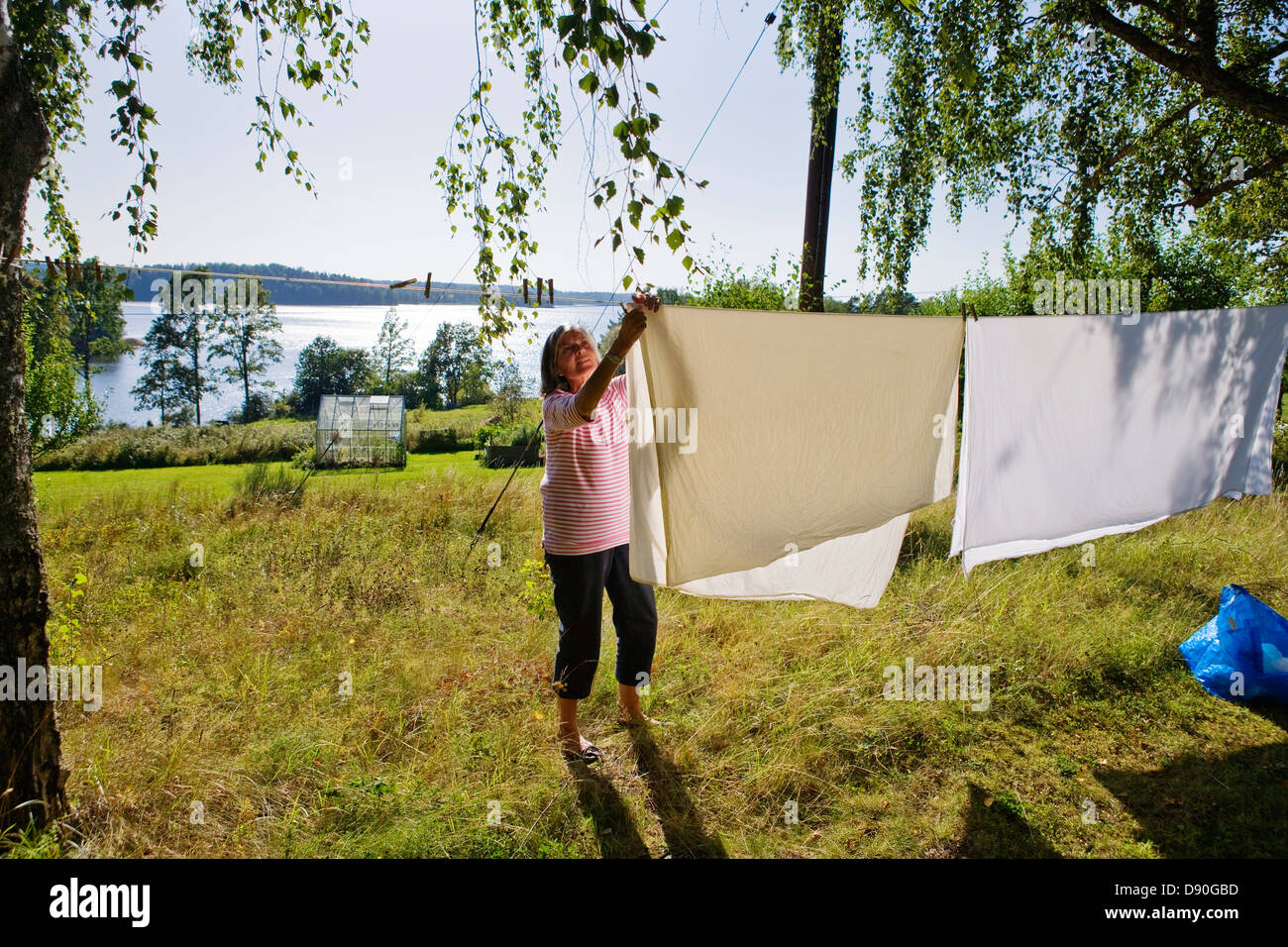 Senior woman setting clothes on washing line Stock Photo Alamy
