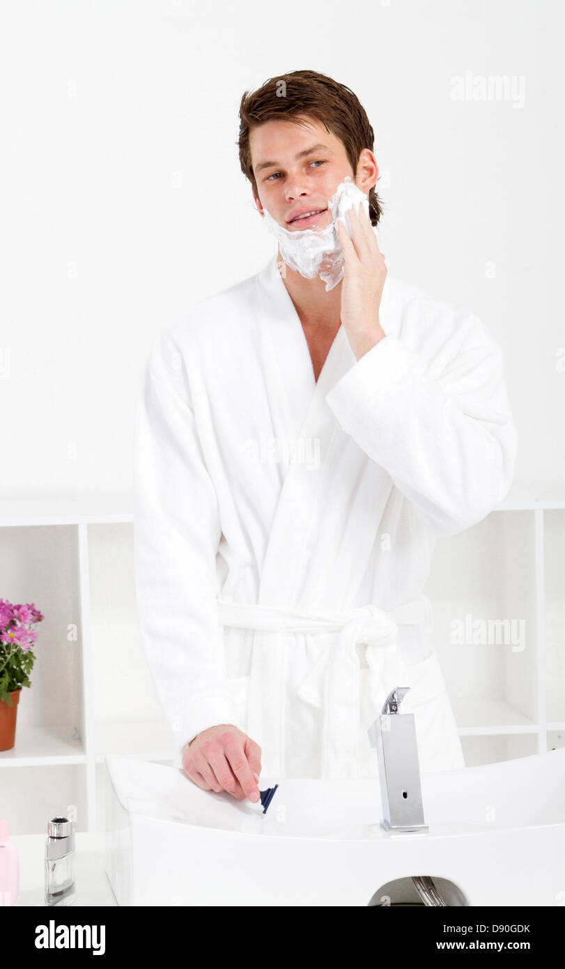 handsome young man apply shaving foam on face in bathroom Stock Photo