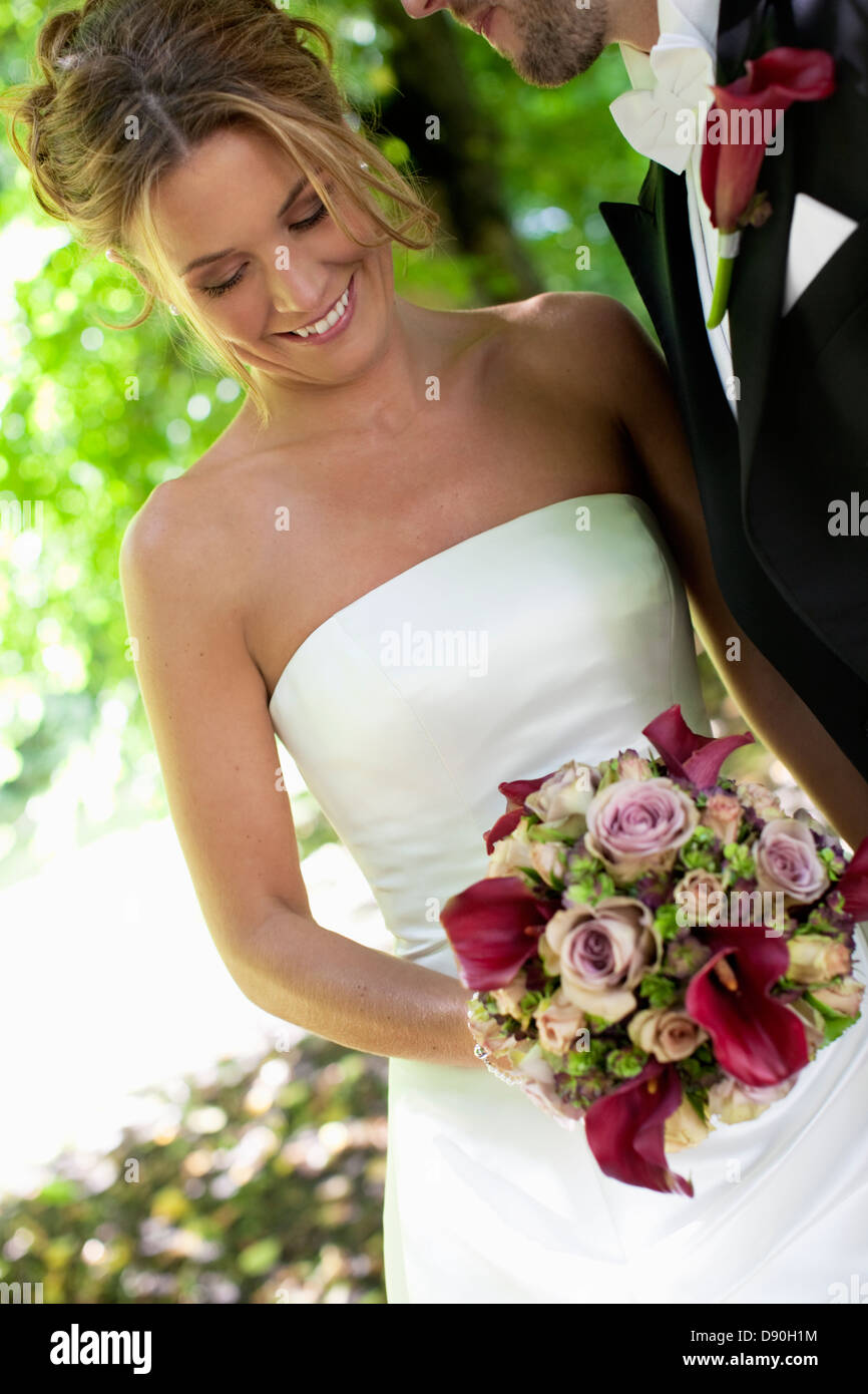 Bride holding bouquet with groom Stock Photo
