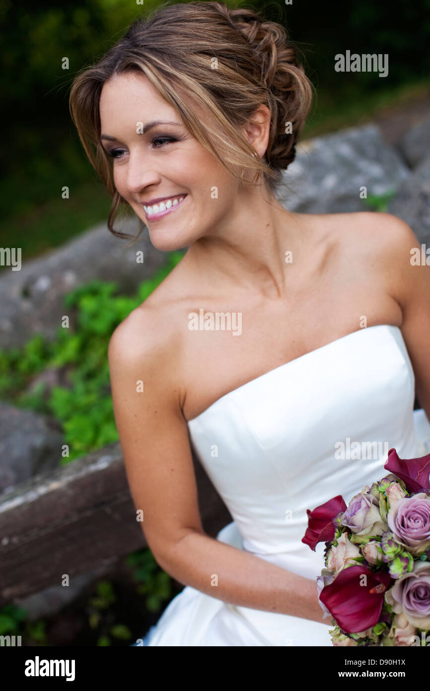 Bride holding bouquet, looking away Stock Photo