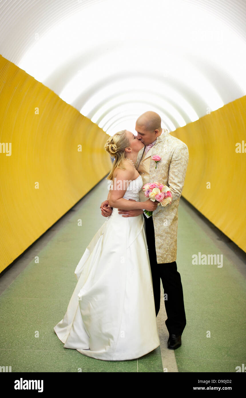 Bride and groom kissing in subway Stock Photo