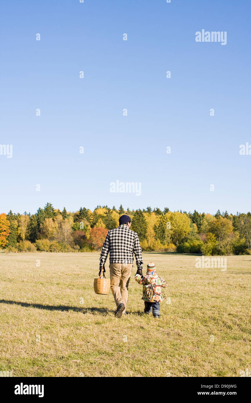 Father and daughter walking through park Stock Photo - Alamy