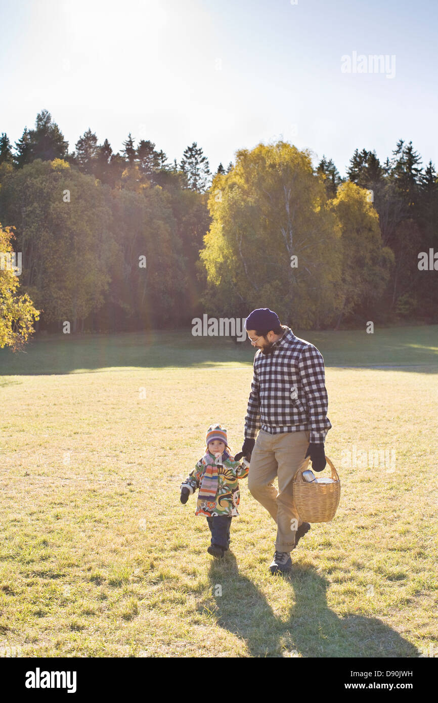 Father and daughter walking through park Stock Photo - Alamy