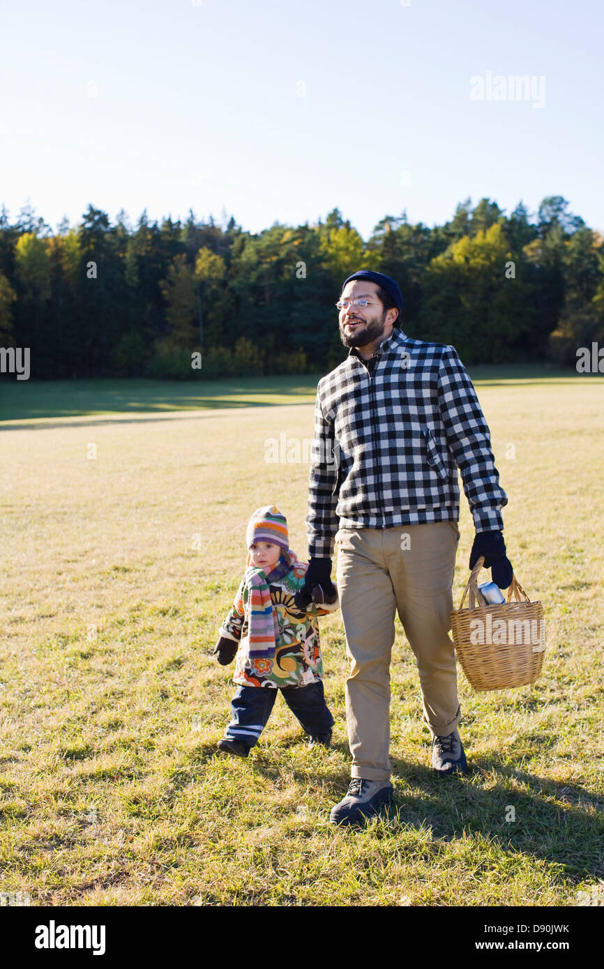 Father and daughter walking through park Stock Photo - Alamy