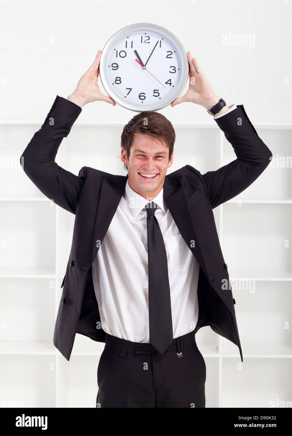 young businessman holding a clock in office Stock Photo Alamy