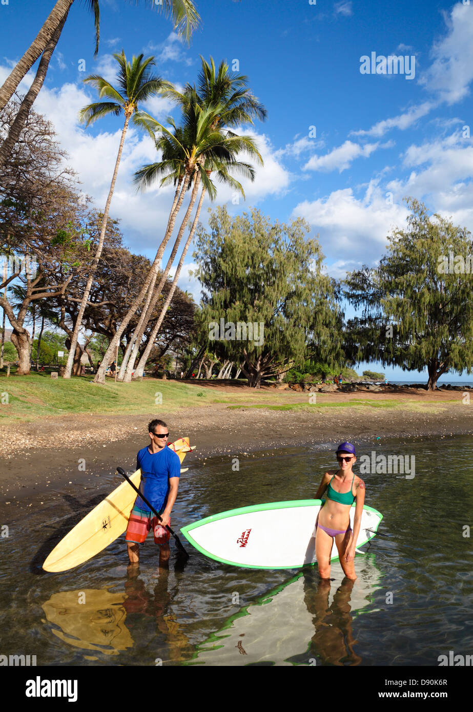 Couple with stand-up paddleboard and surfboard at Launiupoko State Wayside Park just south of Lahaina, Maui Stock Photo