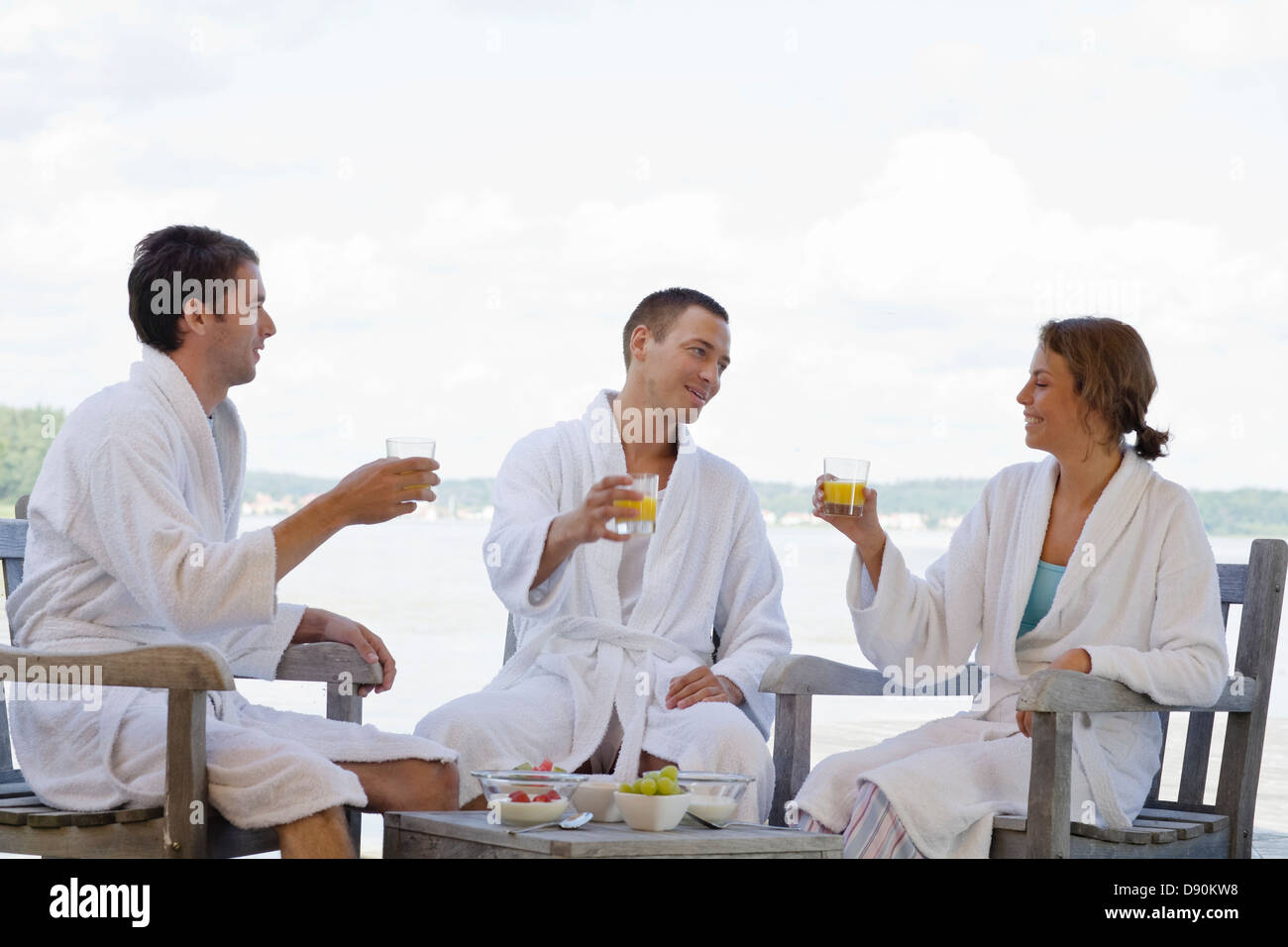 People in bathrobe enjoying breakfast beside lake Stock Photo - Alamy
