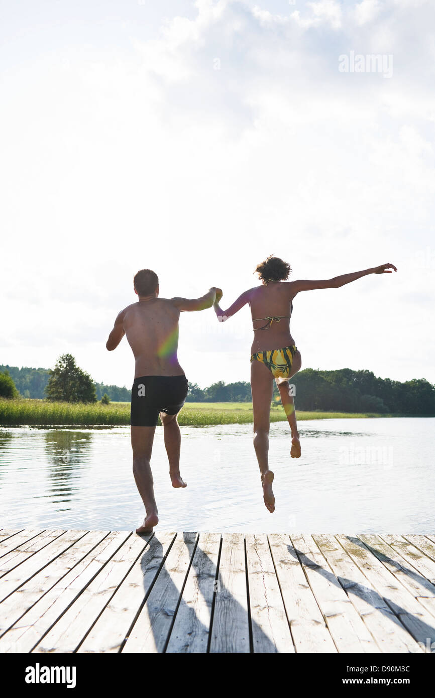 Couple jumping into lake Stock Photo Alamy
