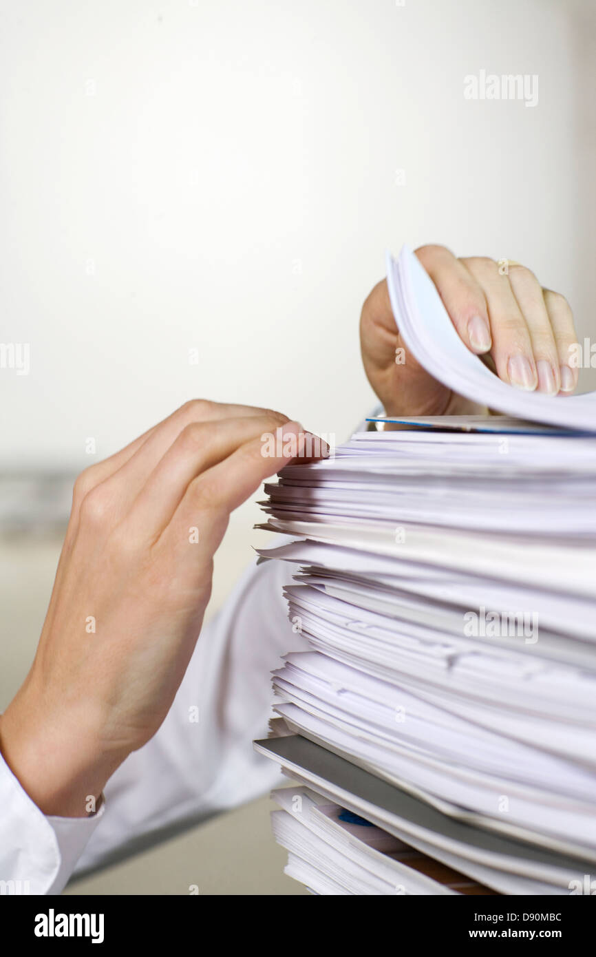 Two hands browsing through a pile of paper in an office Stock Photo Alamy