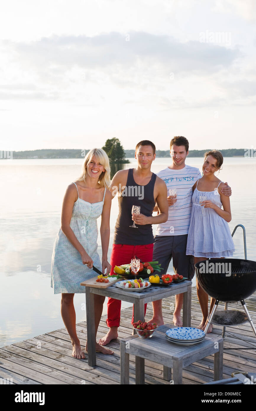 Four people on jetty cooking meal Stock Photo - Alamy