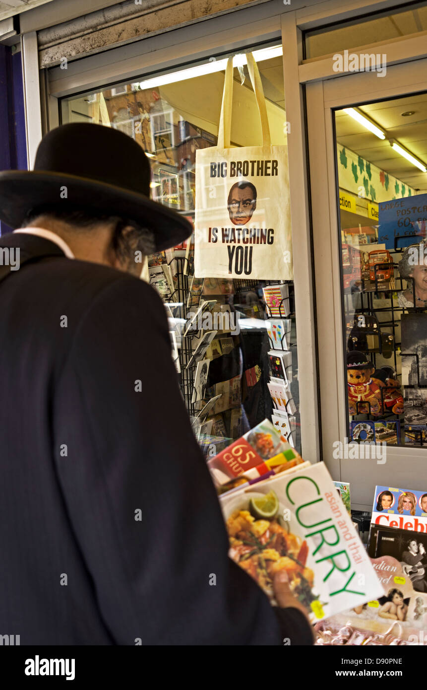 Jewish man browsing books in front of a Big Brother is Watching You tote bag. Stock Photo
