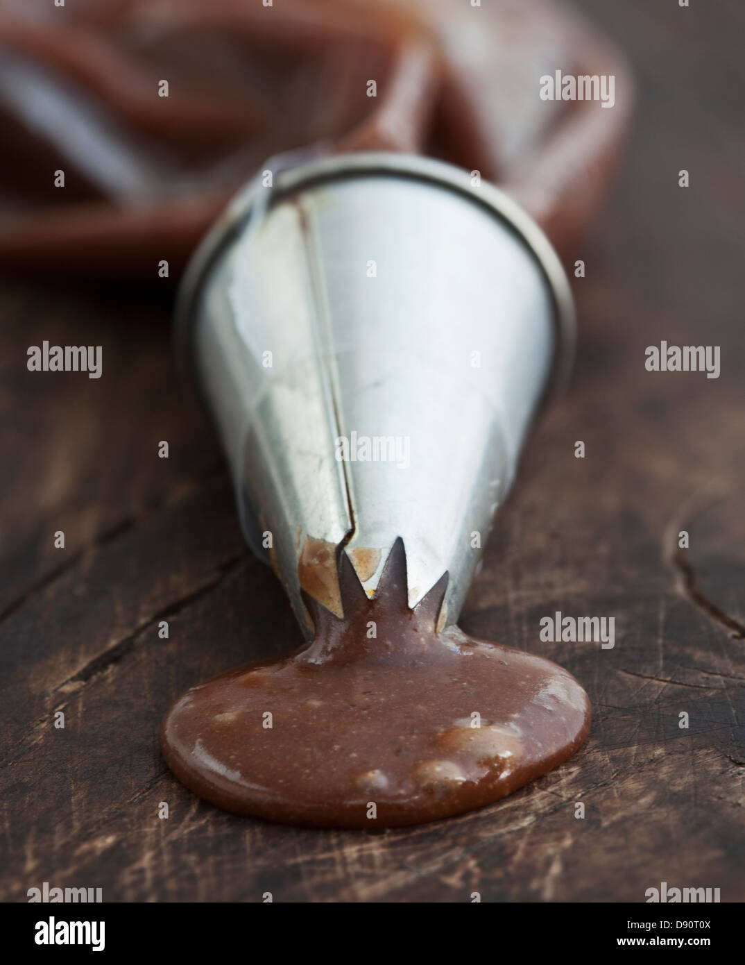 Liquidized chocolate coming out from cone Stock Photo