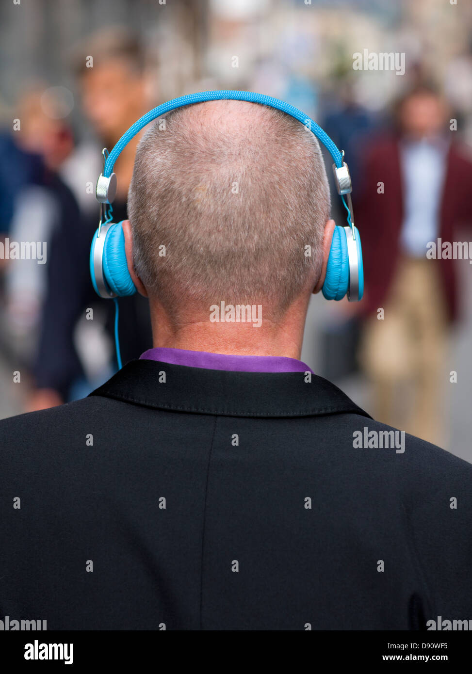 Businessman listening to headphones outdoors Stock Photo