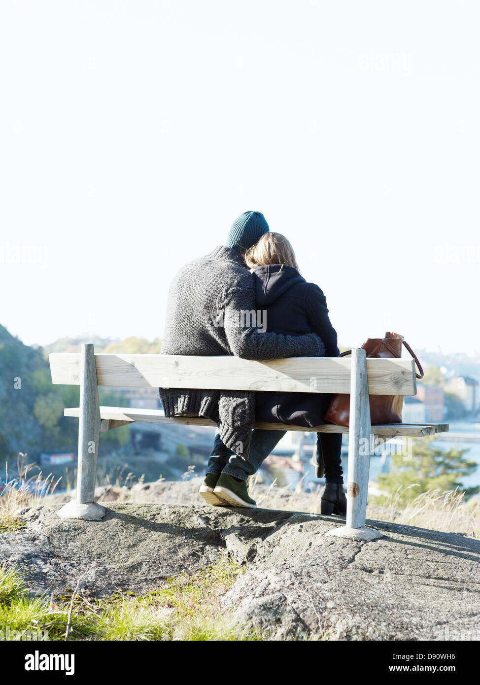 Young couple relaxing on park bench Stock Photo - Alamy
