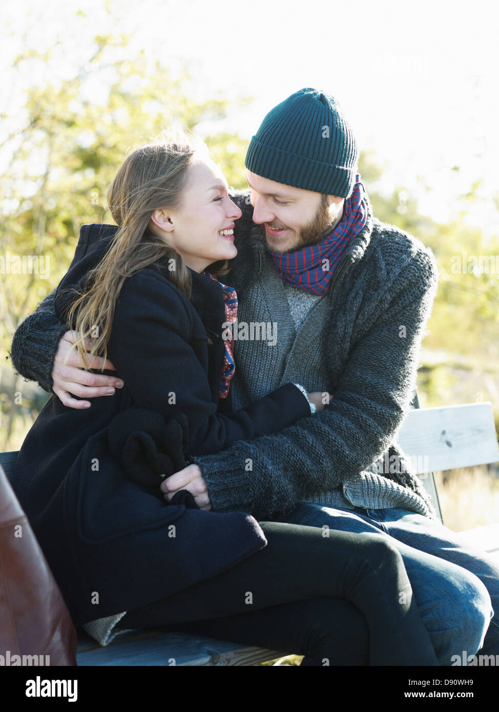 Young couple relaxing on park bench Stock Photo - Alamy