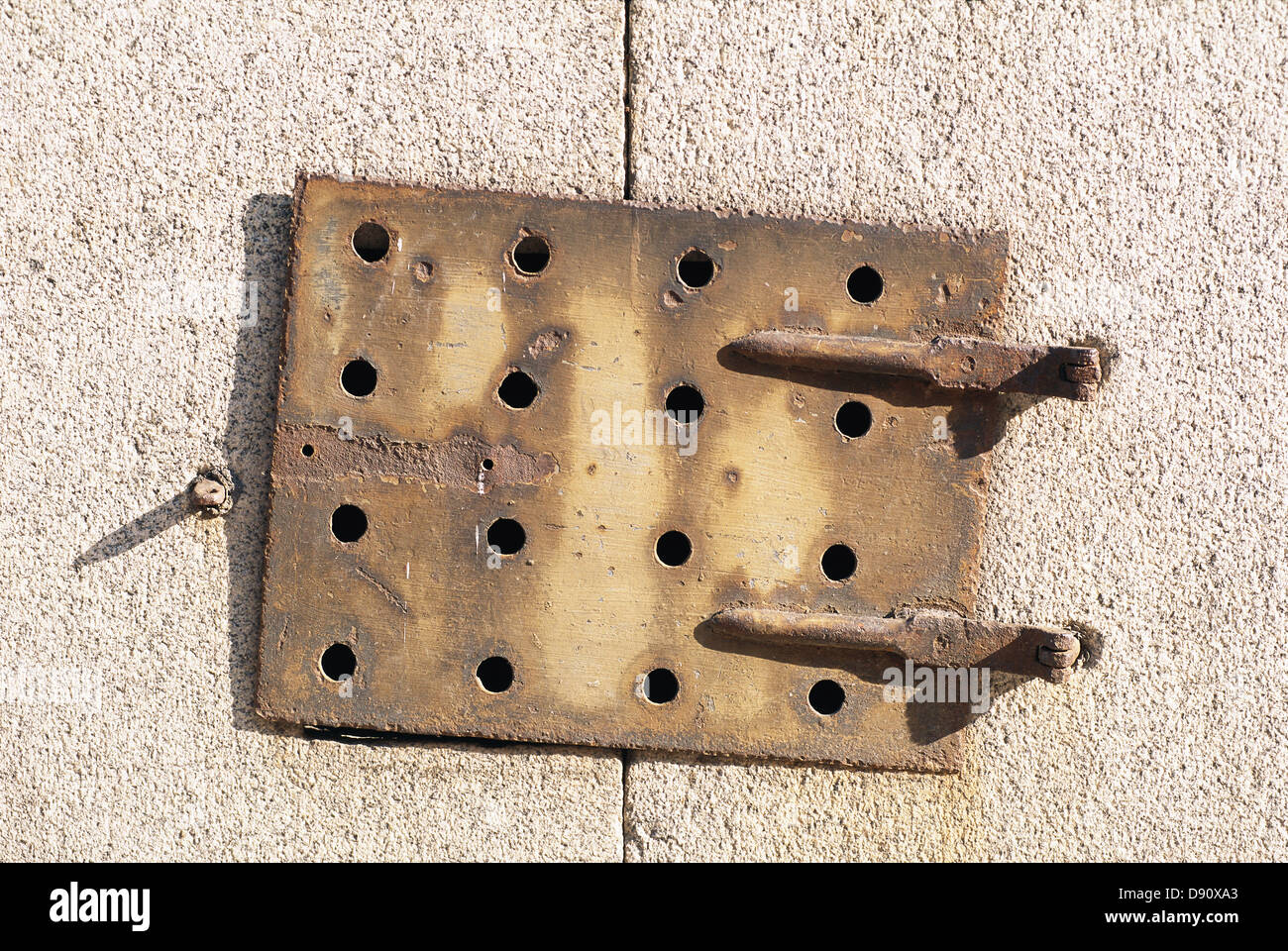 Metal sheet bolted on wall, close-up Stock Photo