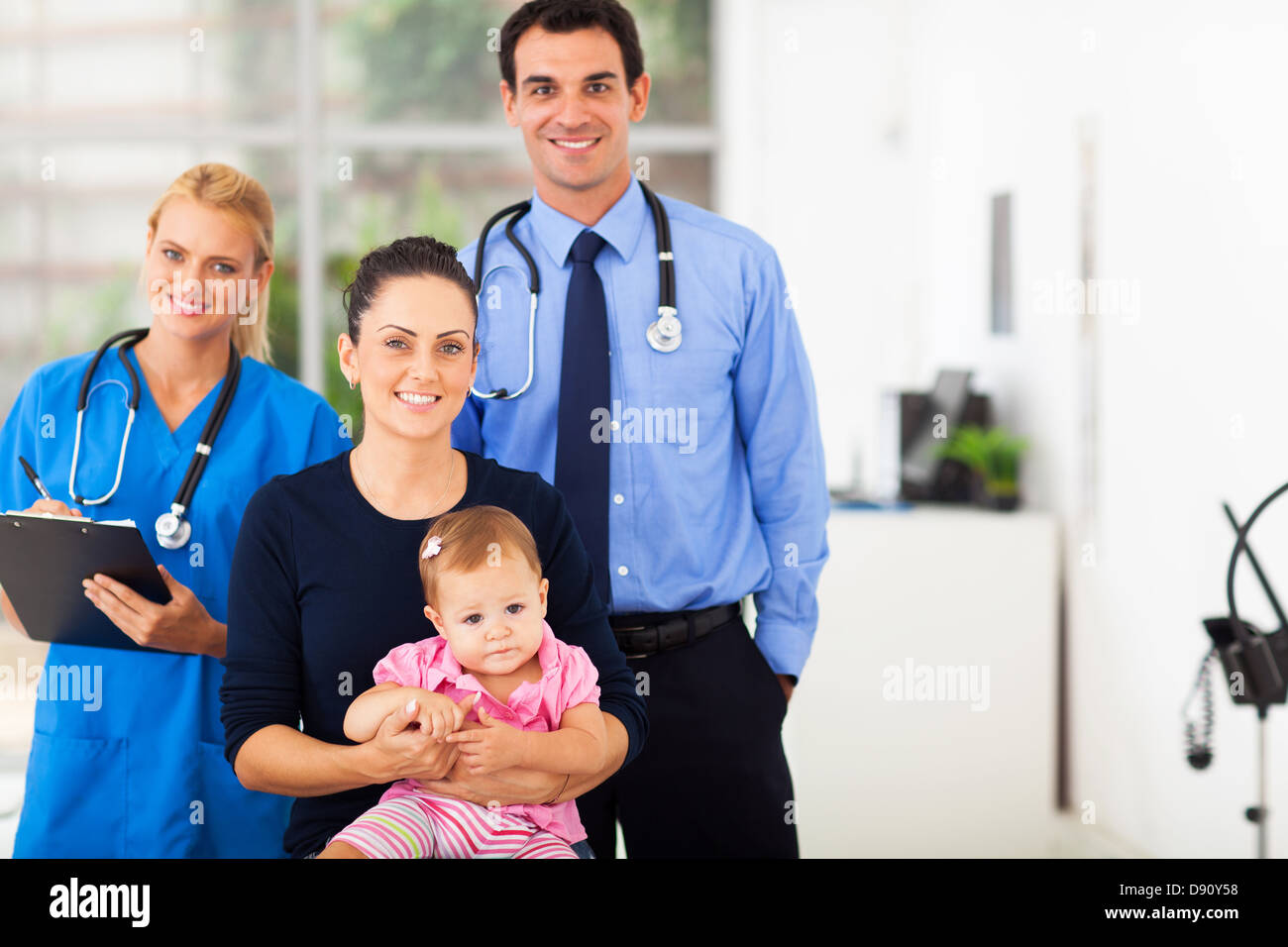 smiling pediatric medical professionals with mother and baby girl Stock Photo