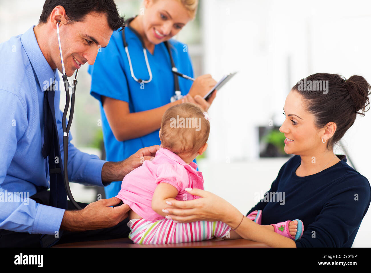 friendly male doctor examining a baby girl in office Stock Photo