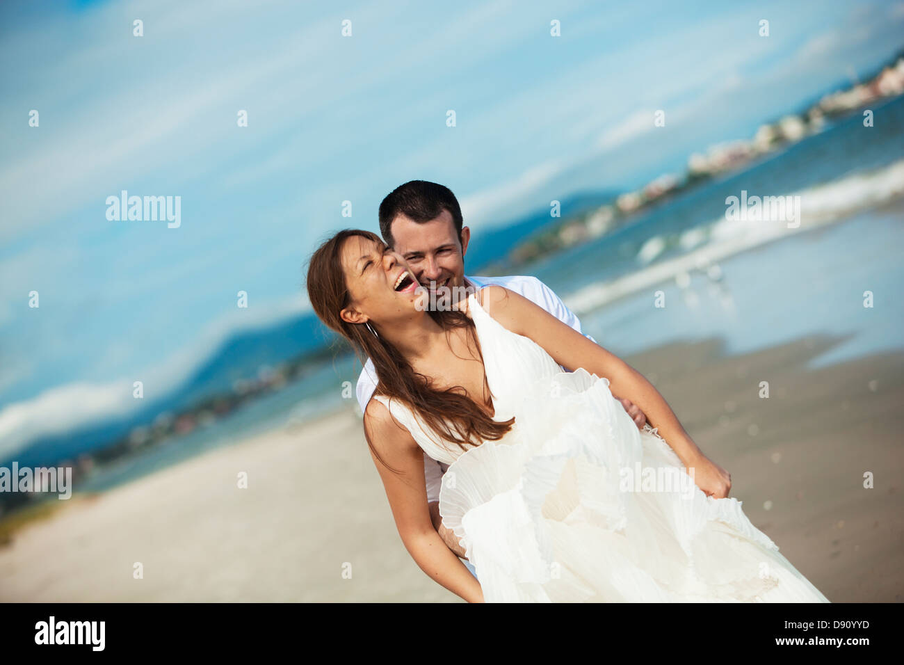 Newlywed couple embracing on beach Stock Photo