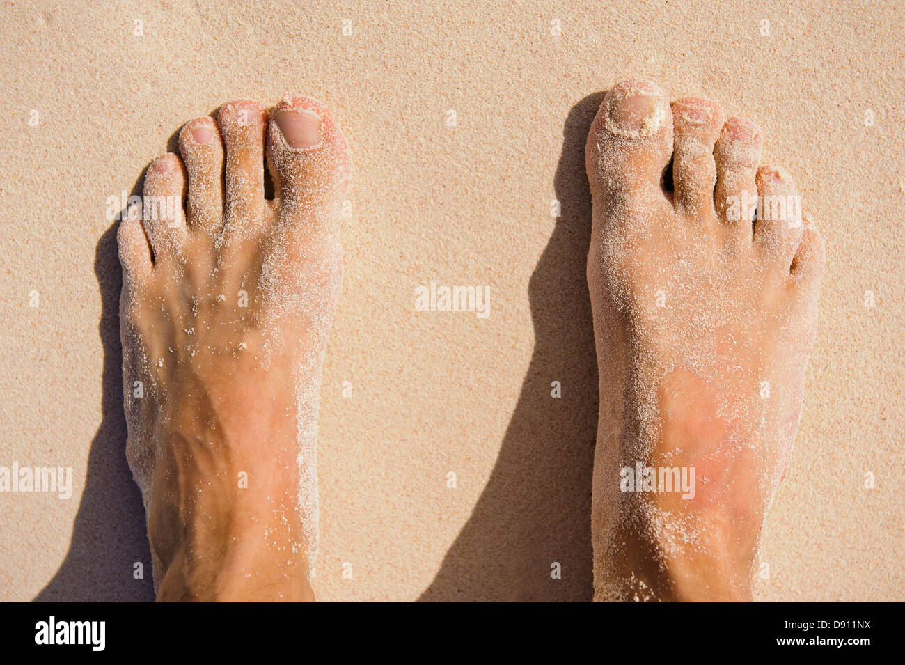 View of mans feet on sand Stock Photo